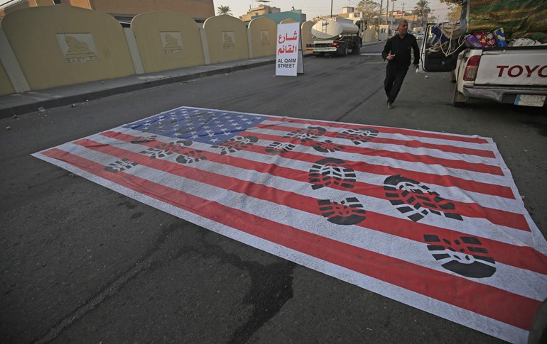 A mock US flag is laid on the ground for cars to drive on in Baghdad on January 3, 2020. Photo: Ahmad al-Rubaye/AFP