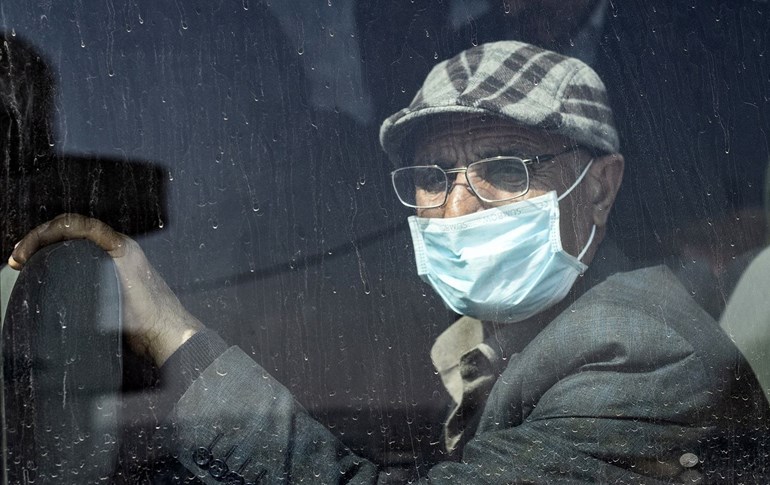 A passenger wears a mask as a preventive measure against the coronavirus upon his arrival by bus into the Kurdistan Region via the Semalka border crossing in northeastern Syria on February 26, 2020. Photo: Delil Souleiman / AFP
