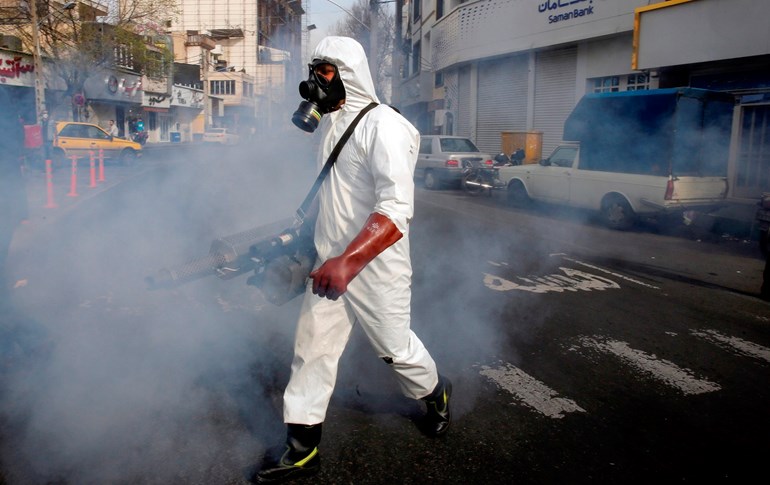 An Iranian firefighter disinfects a street in the capital Tehran. Photo: AFP / STR