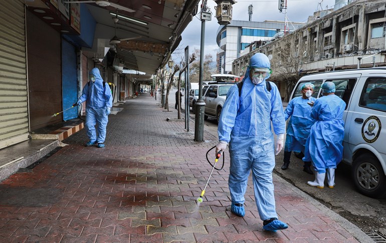 Health workers disinfect a street in Sulaimani on March 14, 2020. Photo: AFP