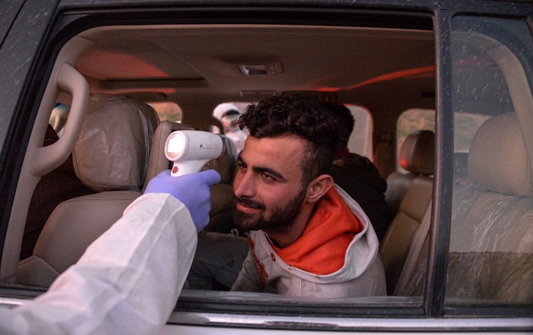 An Iraqi health ministry worker scans the body temperature of a passenger in Mosul on March 8, 2020.Photo: Zaid al-Obeidi/AFP 