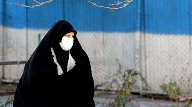 Woman walks the street with mask. Photo: AFP