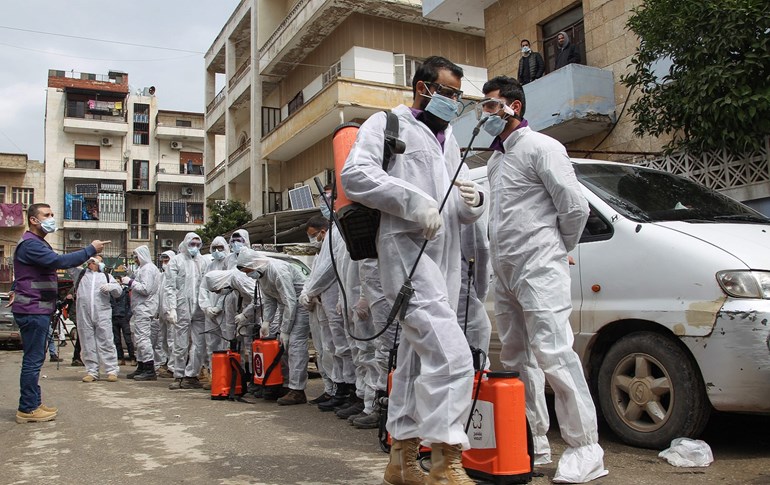 Members of the Syrian Violet NGO prepare to disinfect the Ibn Sina Hospital in Syria's northwestern Idlib city, March 19, 2020. Photo: Abdulaziz Ketaz / AFP