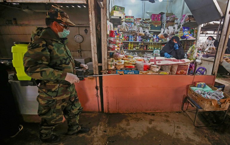 A member of the Iraqi Civil Defence disinfects the alleys of a market in Baghdad's eastern Sadr City suburb on March 28, 2020. Photo: Ahmad Al-Rubaye/ AFP