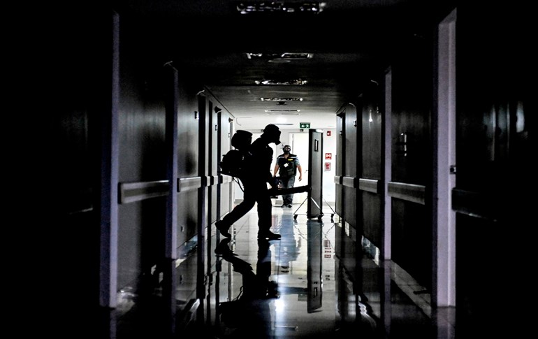 Workers fumigate an abandoned hospital that is being renovated for future COVID-19 patients in Medellin, Colombia, on March 30, 2020. Photo:Joaquin Sarmiento/AFP