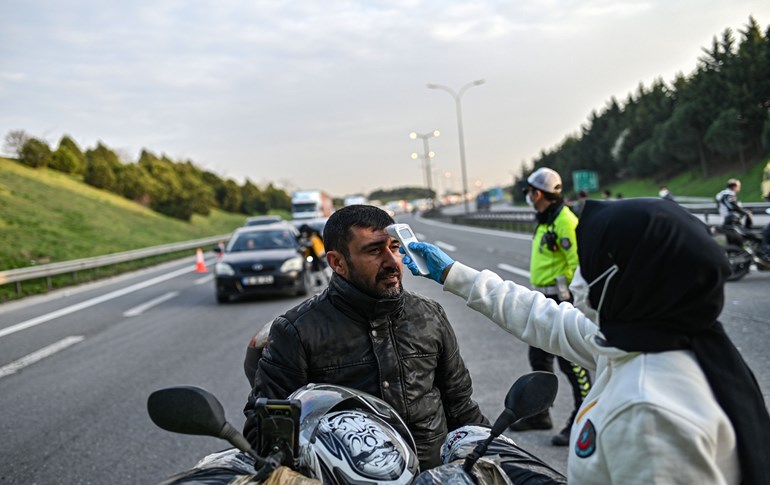 A Turkish health official checks the temperature of a motorcyclist at a checkpoint in Istanbul on March 30, 2020. Photo: Ozan Kose/AFP 