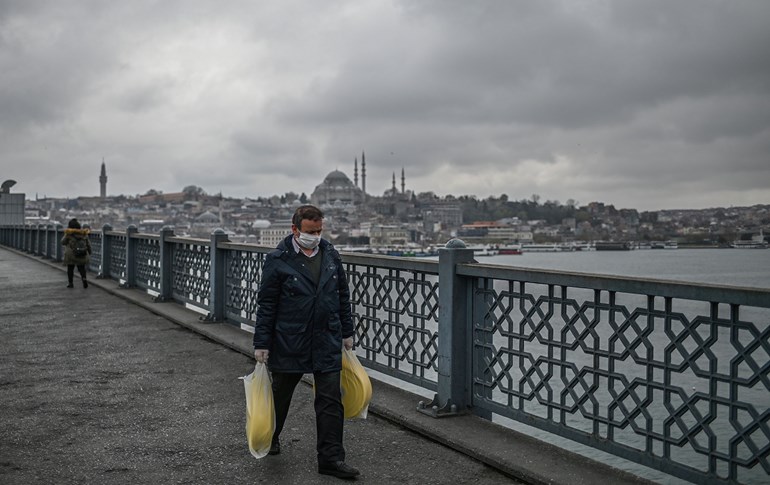 A man wears a facemask as he walks across the empty Galata bridge in Istanbul, on April 1, 2020. Photo: Ozan Kose/AFP