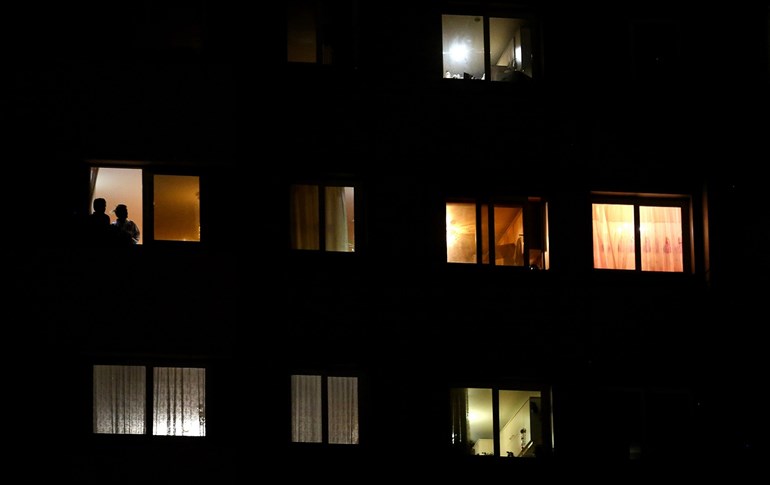 A couple looks out of a window while confined at home due to the COVID-19 pandemic in the Iranian capital Tehran, April 7, 2020. Photo: Atta Kenare / AFP