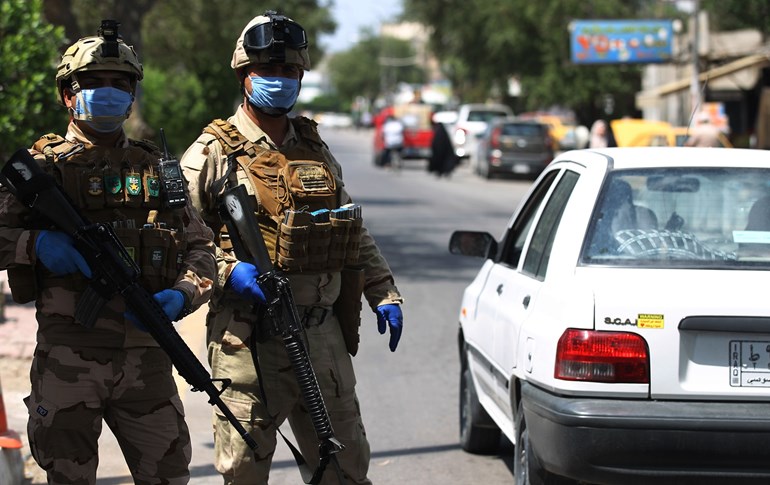 Iraqi soldiers stand at a checkpoint n Baghdad's Adhamiya district on April 13, 2020 as Iraq imposed a curfew during the COVID-19 pandemic. Photo: Ahmad al-Rubaye/AFP