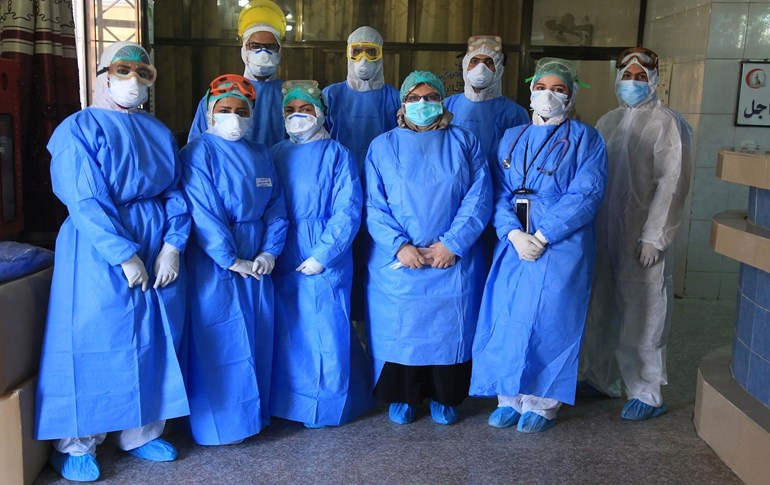 Iraqi health workers pose for a picture at a hospital in Karbala on April 13, 2020. Photo: Mohammed Sawaf / AFP