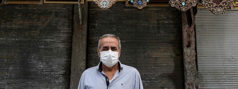   A man wearing a face mask stands outside a closed shop in Erbil on April 16, 2020. Photo: Safin Hamed/AFP   	