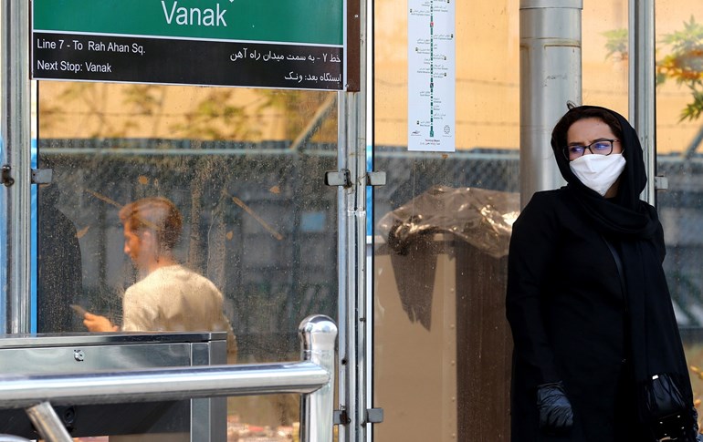 A woman wearing a mask waits for the bus in Tehran on April 21, 2020 amid the coronavirus COVID-19 pandemic. Photo: Atta Kenare/ AFP