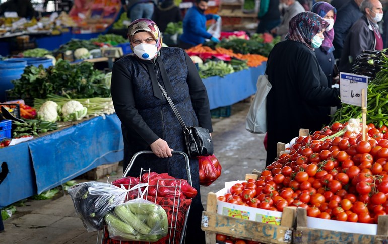 People wearing a protective facemask shop at a street market in Ankara, on April 22, 2020. Photo: Adem A