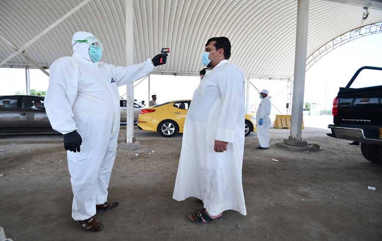 A health worker checks a resident's temperature at the entrance of the Iraqi southern city of Nasiriyah, Dhi Qar province on April 22, 2020. Photo: Asaad Niazi / AFP