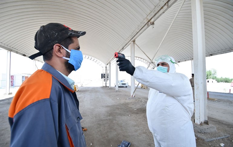 A health worker checks the temperature of a resident at the entrance of the Iraqi southern city of Nasiriyah in Dhi Qar province on April 22, 2020. Photo: Asaad Niazi / AFP