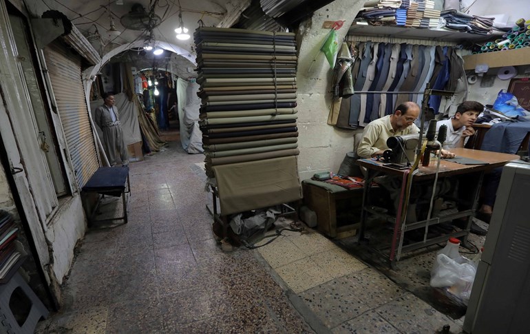 A man sews cloth at his shop on April 24, 2020, in Arbil, the capital of the northern Iraqi Kurdish autonomous region, after authorities reduced restrictions on movement. Photo: Safin Hamed/ AFP