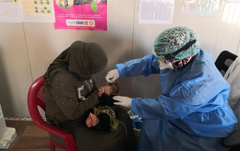 A mother holds her child as she receives polio drops. File photo: Department of Health / UNICEF