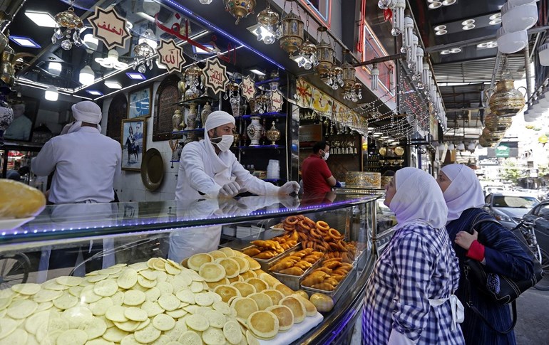 Syrians buy sweets for iftar during the Muslim holy month of Ramadan, at the Maidan market in Damascus on April 26, 2020. Photo: Louai Beshara / AFP