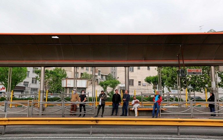  Iranian men wait for the bus at a station in the capital Tehran, on April 26, 2020. Photo: Atta Kenare/AFP