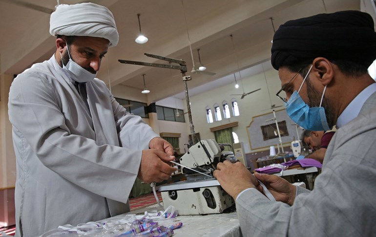 Iraqi Shiite clerics work in the al-Sadiqeen mosque in Baghdad turned into a mask production centre, April 27, 2020. Photo: Ahmad al-Rubaye / AFP 