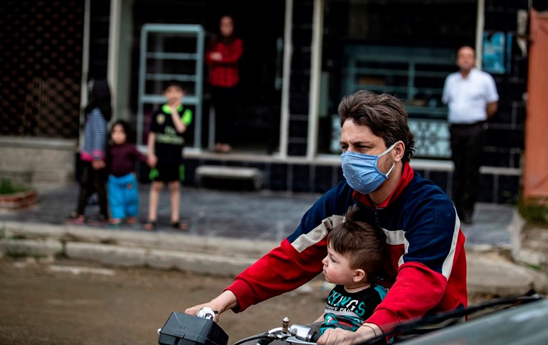 A Syrian man, wearing a protective face mask, rides a motorcycle with his son in the city of Qamishli in Syria's northeastern Hasaka province, April 24, 2020. Photo: Delil Souleiman / AFP