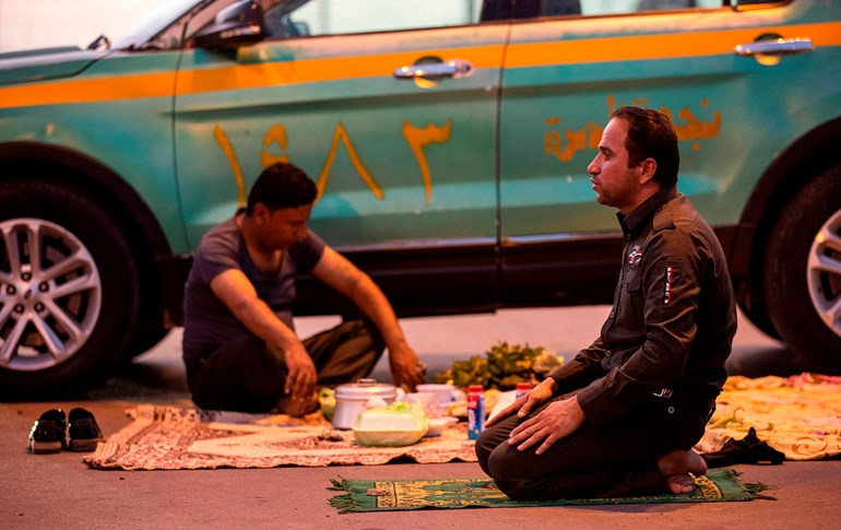 A policeman performs the maghreb (sunset) prayer before breaking fast in Iraq's southern city of Basra, April 30, 2020. Photo: Hussein Faleh / AFP 