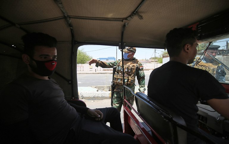 Iraqi soldiers stop a tuk-tuk at a checkpoint to ensure compliance with the rules in Baghdad's Sadr City on June 3, 2020 amid a curfew. Photo: Ahmad al-Rubaye/ AFP