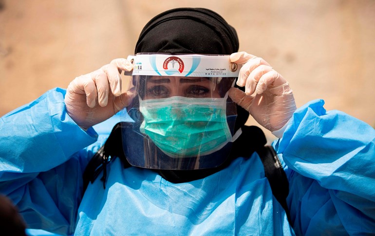  A medical worker adjusts her protective headgear in Basra on June 2, 2020. Photo: Hussein Faleh/AFP