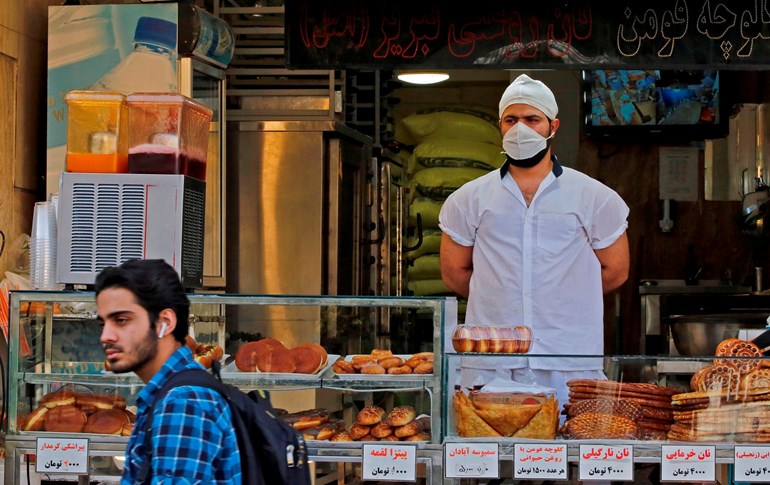 An Iranian man walks in front of a pastry shop in the capital Tehran on June 3, 2020. Photo: AFP  	