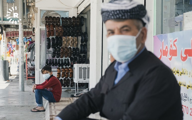 A man and boy sit outside a shop in Erbil on June 4, 2020. Photo: Bilind T.Abdullah/Rudaw