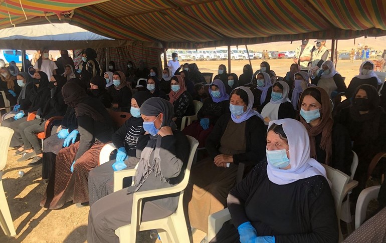 About 100 women wearing face masks have gathered, waiting for a ceremony marking the start of exhumation of a mass grave of ISIS victims in Solagh, Shingal region on October 24, 2020. Photo: Fazel Hawramy/Rudaw
