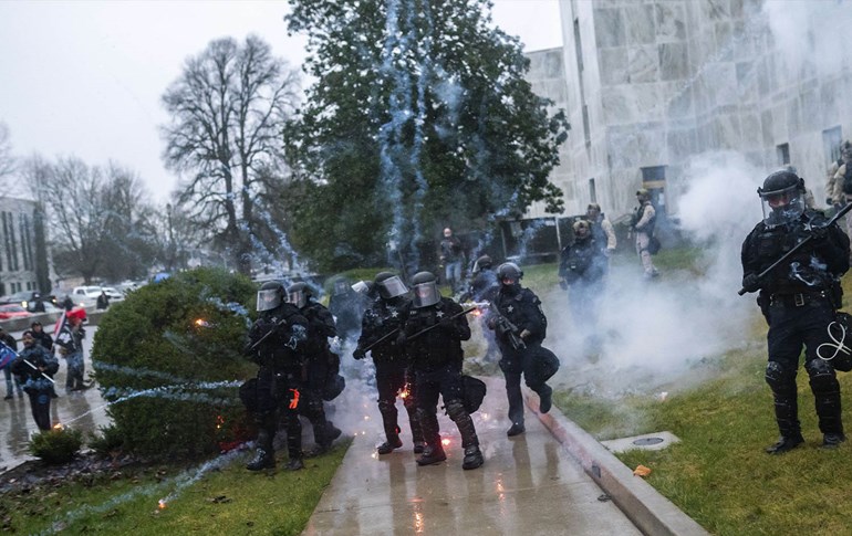 رووبەڕووبوونەوەی هێزە ئەمنییەکان لەگەڵ خۆپێشاندەران. وێنە: Nathan Howard/AFP