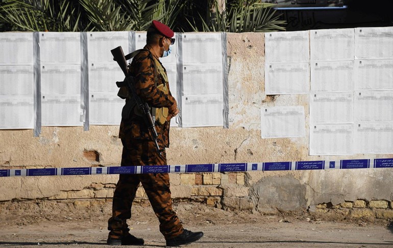 کارمەندێکی هێزە ئەمنییەکان لە بەردەم بنکەیەکی دەنگدان لە ناسریە. وێنە؛ Asaad NIAZI / AFP