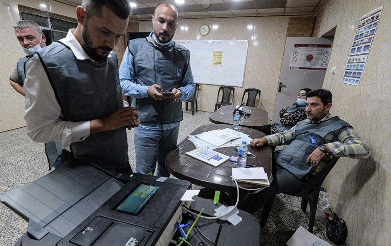 Iraqi election officials conduct the electronic count of votes at a polling station in Mosul on October 10, 2021. Photo: Zaid al-Obeidi/AFP
