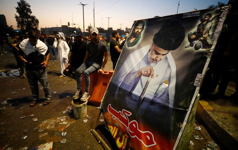 Supporters of Shiite cleric Muqtada al-Sadr alongside a poster of the cleric in Baghdad on August 29, 2022. Photo: Ahmad al-Rubaye/AFP