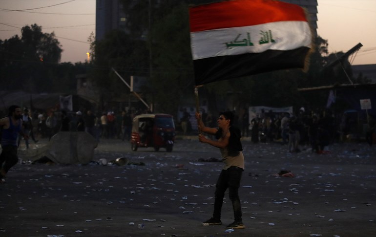 A supporter of Iraqi Shiite cleric Muqtada al-Sadr waves the Iraqi flag in Baghdad amid escalating violence on August 29, 2022. Photo: Ahmad al-Rubaye/AFP