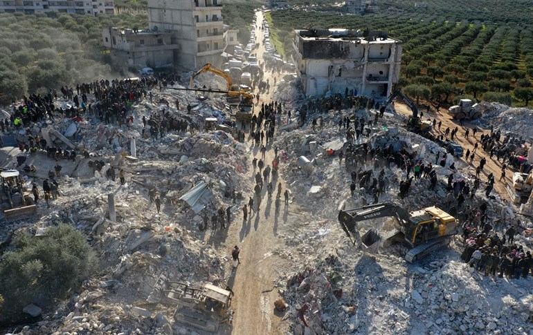 An aerial picture shows rescuers searching the rubble of buildings for casualties and survivors in the village of Besnaya in Syria's rebel-held northwestern Idlib province at the border with Turkey following an earthquake, on February 7, 2023. Photo: Omar Haj Kadour/AFP