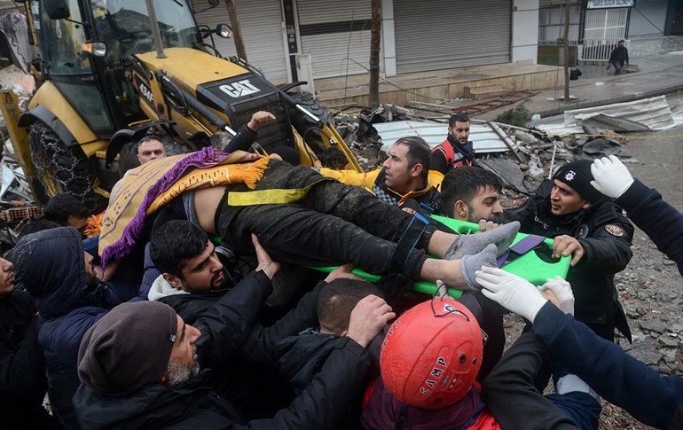 Rescue workers and volunteers carry a person rescued from the rubble in Diyarbakir on February 6, 2023. Photo: Ilyas Akengin/AFP