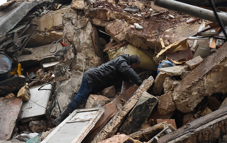 A man looks for survivors under the rubble of a collapsed building after an earthquake in the regime-controlled northern Syrian city of Aleppo on February 6, 2023. Photo: AFP