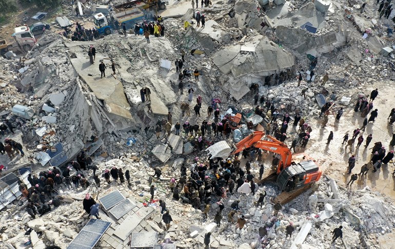 This aerial view shows residents, aided by heavy equipment, searching for victims and survivors amidst the rubble of collapsed buildings following an earthquake in the village of Besnia near the town of Harim, in Syria's rebel-held noryhwestern Idlib province on the border with Turkey, on February 6, 2022. Photo: AFP