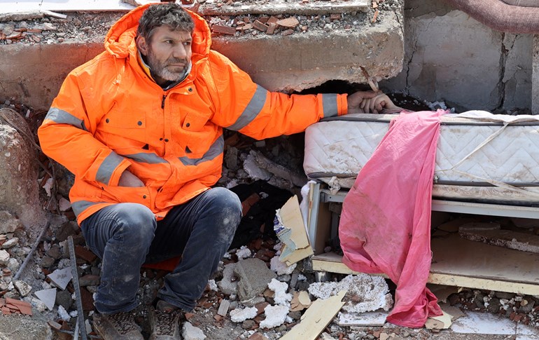 Mesut Hancer holds the hand of his 15-year-old daughter Irmak, who died in the earthquake in southern Turkey’s Kahramanmaras, on February 7, 2023. Photo: Adem Altan/AFP