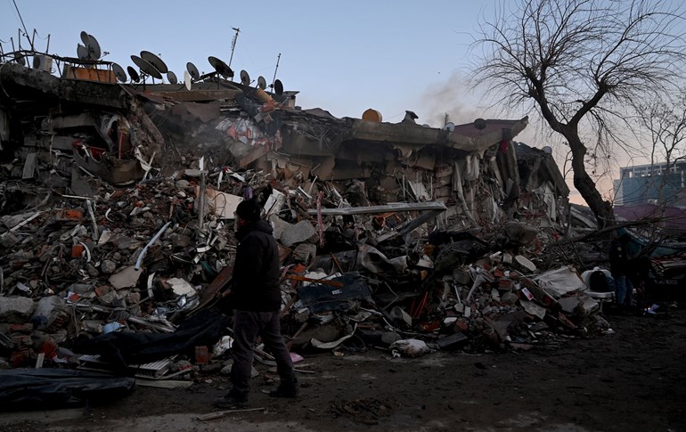 A man walks part the rubble of collapsed buildings in Kahramanmaras, on February 7, 2023. Photo: Ozan Kose/AFP