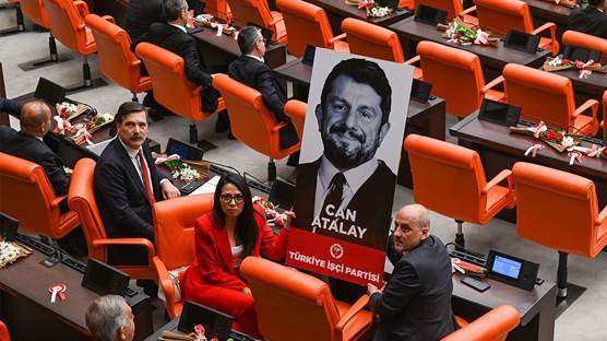 Du parlamenterên Partiya Karkerên Tirkiyê (TÎP) wêneyê Can Atalay ku di hilbijartinên 14ê Gulanê de wek parlamenterê Hatayê yê wê partiyê hat hilbijartin, di civîna parlamentoya Tirkiyê de bilind kirine. Wêne: AA 