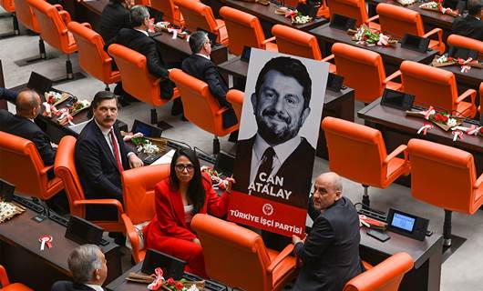 Du parlamenterên Partiya Karkerên Tirkiyê (TÎP) wêneyê Can Atalay ku di hilbijartinên 14ê Gulanê de wek parlamenterê Hatayê yê wê partiyê hat hilbijartin, di civîna parlamentoya Tirkiyê de bilind kirine. Wêne: AA 