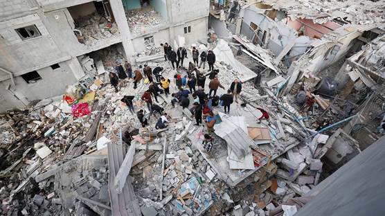 İsrail ordusunun Gazze'nin orta kesiminde yer alan Nuseyrat Mülteci Kampındaki el Tavil ailesine ait binaya düzenlediği saldırıda bina yıkıldı. Bölgedeki vatandaşlar, yıkılan binanın enkazında arama kurtarma çalışması yaptı. / AA