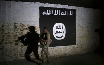 An Iraqi soldier inspects a train tunnel, adorned with an ISIS group flag. File photo: AP.