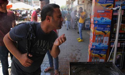 An Iraqi man uses a curbside shower to cool off during a heat wave in the capital Baghdad in June, 2019. Photo: AFP