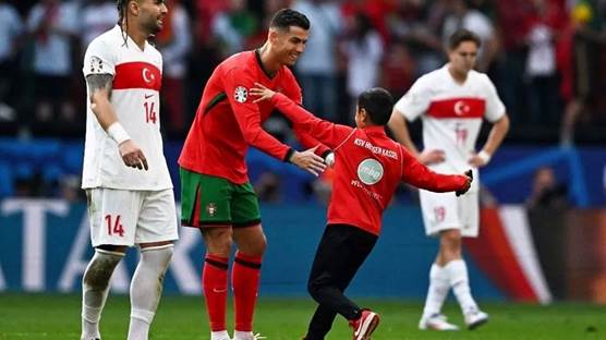 Foto: EURO 2024’te cumartesi günü oynanan Türkiye-Portekiz maçında bir çocuğun sahaya girerek Cristiano Ronaldo ile fotoğraf çektirmesi sosyal medyada gündem oldu
