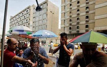عراقيون يستخدمون مرشات المياه لتخفيف من درجات الحرارة 